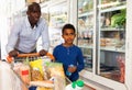 Happy friendly African family of father and tween son shopping together in supermarket Royalty Free Stock Photo