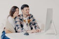 Happy friendly couple sit together with dog, make booking of hotel for future trip, keyboard and look at computer, chat online, Royalty Free Stock Photo