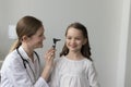 Happy friendly female pediatrician examining preschool girls ear Royalty Free Stock Photo
