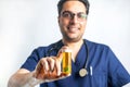 Happy and friendly male medical doctor offers a bottle of pills to a client with a smile. Smiling and positive healthcare Royalty Free Stock Photo