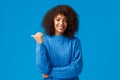 Happy friendly outgoing, pretty african-american female in winter sweater, sharing link, giving advice, pointing thumb Royalty Free Stock Photo