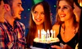 Happy friends birthday party with candle celebration cakes in club. Royalty Free Stock Photo
