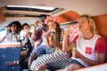 Happy friends blowing bubble wands in camper van