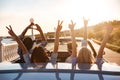 Happy friends in cabriolet with raised hands driving on sunset Royalty Free Stock Photo