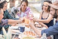 Happy friends cheering at breakfast brunch meal in nature outdoor - Young people having fun together eating fruits and drinking Royalty Free Stock Photo