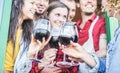 Happy friends cheering with red wine at barbecue dinner - Young people having fun and laughing together in mountain vineyard farm