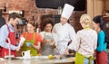 Happy friends and chef cook cooking in kitchen Royalty Free Stock Photo