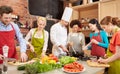 Happy friends and chef cook cooking in kitchen Royalty Free Stock Photo