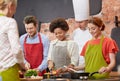 Happy friends and chef cook cooking in kitchen Royalty Free Stock Photo
