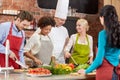 Happy friends and chef cook cooking in kitchen Royalty Free Stock Photo