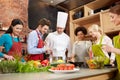 Happy friends and chef cook cooking in kitchen Royalty Free Stock Photo