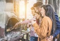 Happy friends cooking meat and drinking wine at barbecue outdoor - Young people having fun grilling for bbq in house backyard at Royalty Free Stock Photo