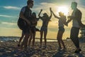 Happy friends dancing on the beach. Men is playing guitar