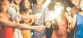 Happy friends dancing and drinking champagne at party night - Young people having fun with sparklers fireworks in night club - Royalty Free Stock Photo