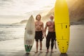 Happy friends with different age surfing together - Sporty people having fun during vacation surf day