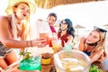 Happy friends drinking at beach cocktail bar wearing face masks - New normal summer concept with people having fun together Royalty Free Stock Photo