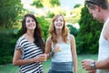 Happy, friends and drinks in backyard of home with juice, laughing and conversation in garden. BBQ, young people with Royalty Free Stock Photo