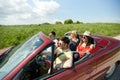 Happy friends driving in cabriolet car at country Royalty Free Stock Photo