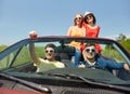 Happy friends driving in cabriolet car at country Royalty Free Stock Photo