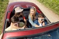 Happy friends driving in cabriolet car at country Royalty Free Stock Photo