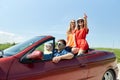 Happy friends driving in cabriolet car at country Royalty Free Stock Photo