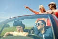 Happy friends driving in cabriolet car at country Royalty Free Stock Photo