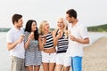 Happy friends eating ice cream on beach