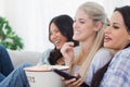 Happy friends eating popcorn and watching tv Royalty Free Stock Photo