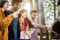 Happy friends eating sausages and drinking wine at barbecue outdoor - Young people grilling meat for bbq in house backyard - Royalty Free Stock Photo