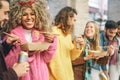 Happy friends eating street food and drinking beers outdoor - Group trendy people having fast meal together