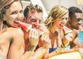 Happy friends eating watermelon in swimming pool hotel resort -  Diverse culture couples having fun in summer vacation - Travel, Royalty Free Stock Photo