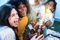 Happy friends enjoying party on rooftop terrace - Group of multiracial young people drinking beer bottle at brewery pub garden - Royalty Free Stock Photo