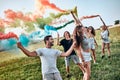 Happy friends enjoying party, using smoke bombs colors at party outdoor. Young students having fun together Royalty Free Stock Photo