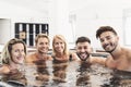 Happy friends enjoying vacations in jacuzzi luxury house - Young people having fun together in hot tub Royalty Free Stock Photo