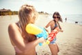 Happy friends girls playing with water gun.Travel on vacation at sea Royalty Free Stock Photo