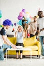 Happy friends greeting young woman