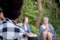 Happy friends group doing recreation with man playing guitar and friends and children singing at camping together. Royalty Free Stock Photo