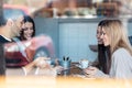 Happy friends group eating burgers while talking about work using digital tablet sitting in restaurant Royalty Free Stock Photo