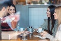 Happy friends group eating burgers while talking about work using digital tablet sitting in restaurant Royalty Free Stock Photo