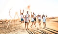 Happy friends group having fun at ferris wheel seaside - Summer vacations friendship concept with millenial guys and girls