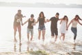 Happy friends have fun on the beach - Young people playing in open air water on summer holidays Royalty Free Stock Photo