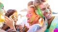 Happy friends having fun at beach party on holi colors festival event - Young people laughing together with candid excited mood