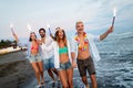 Happy friends having fun beach party outdoor with fireworks Royalty Free Stock Photo