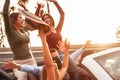 Happy friends having fun on convertible car in road trip - Group young people enjoying vacation together in tropical city Royalty Free Stock Photo