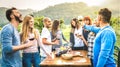 Happy friends having fun drinking red wine in vineyard - Milenial people enjoying harvest time together at countryside farm house Royalty Free Stock Photo