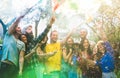 Happy friends having fun at garden party with multicolored smoke