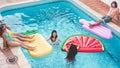 Happy friends having fun inside swimming pool - Young people enjoying summer holidays vacation in tropical hotel resort - Travel, Royalty Free Stock Photo