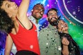 Happy friends having fun in night club dance floor with canon ball throwing confetti - Young people enjoying weekend nightlife - Royalty Free Stock Photo