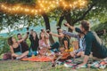 Happy friends having fun at picnic dinner with vintage lights outdoor next vineyard - Young people cheering with red wine on Royalty Free Stock Photo