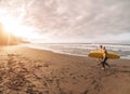 Happy friends having fun surfing on sunset time - Surfers father and son running on beach Royalty Free Stock Photo